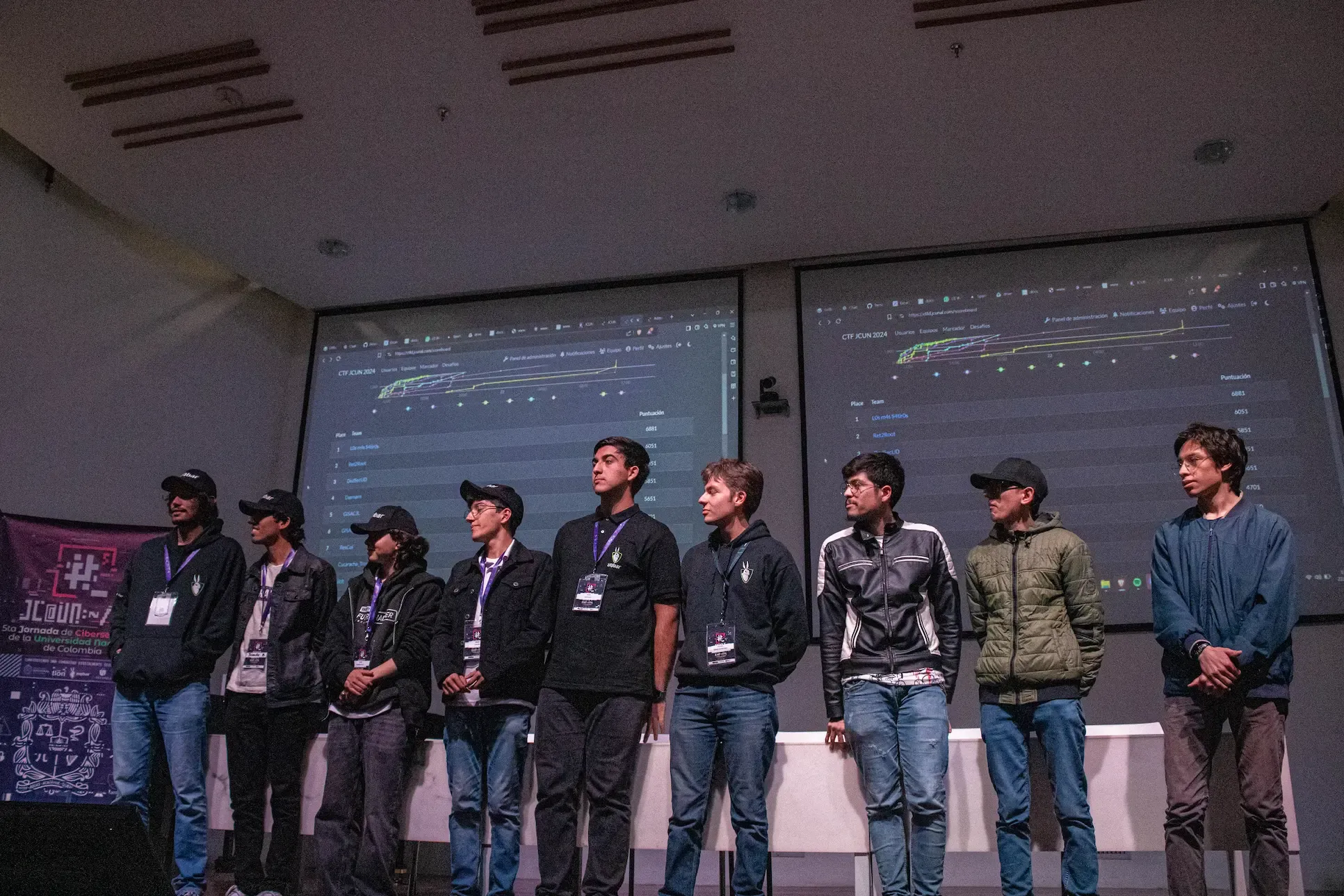 Participantes del CTF JCUN en el escenario, con el marcador de la plataforma CTFd proyectado detrás.